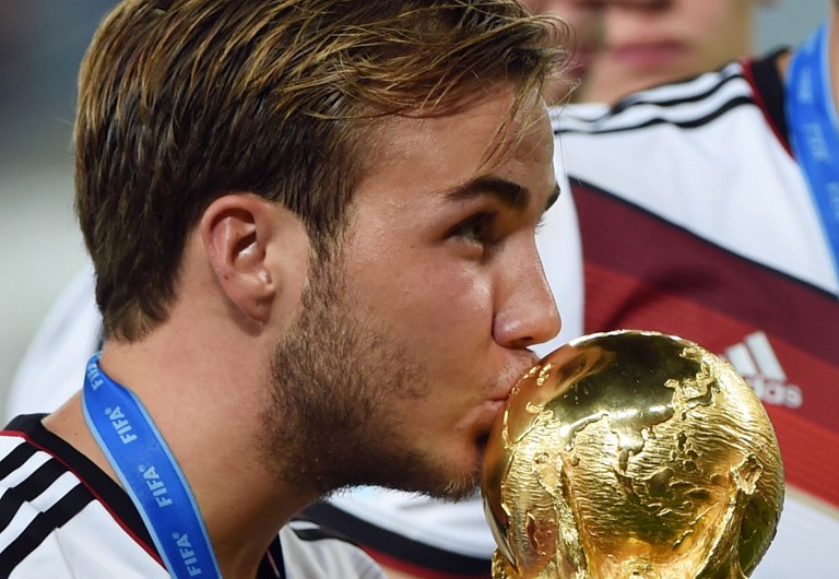 Der deutsche Stürmer Mario Götze küsst die WM-Trophäe, während seine Mannschaft den 1:0-Sieg im Finale der FIFA Fußball-Weltmeisterschaft 2014 zwischen Deutschland und Argentinien nach der Verlängerung im Maracana-Stadion in Rio de Janeiro, Brasilien, feiert. AFP PHOTO / PATRIK STOLLARZ