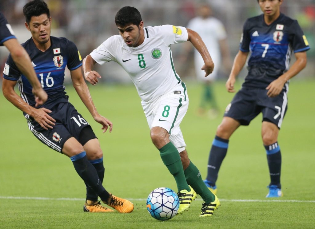 Saudi-Arabiens Yahia Alshehri (C) kämpft um den Ball gegen Japans Hotaru Yamaguchi (L) und seinen Teamkollegen Shibasaki Gacu während des Qualifikationsspiels zur FIFA Fussball-Weltmeisterschaft 2018 zwischen Saudi-Arabien und Japan im King Abdullah bin Abdulaziz Stadium in Jeddah am 5. September 2017. Der Siegtreffer von Fahad Al Muwallad in der zweiten Halbzeit brachte Saudi-Arabien zu seiner fünften Weltmeisterschaft und verwies Australien mit dem 1:0-Sieg gegen Japan in Jeddah in die Playoffs. / AFP PHOTO / STR