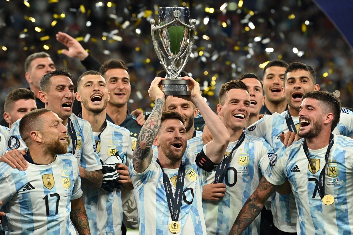 Der argentinische Stürmer Lionel Messi hebt den Pokal in die Höhe, während die argentinischen Spieler nach dem Sieg im internationalen Freundschaftsspiel "Finalissima" zwischen Italien und Argentinien im Wembley-Stadion in London am 1. Juni 2022 auf dem Spielfeld feiern. - Die Azzurri treffen in der ersten Finalissima in Wembley auf den südamerikanischen Kontinentalmeister. (Foto: Glyn KIRK / AFP)