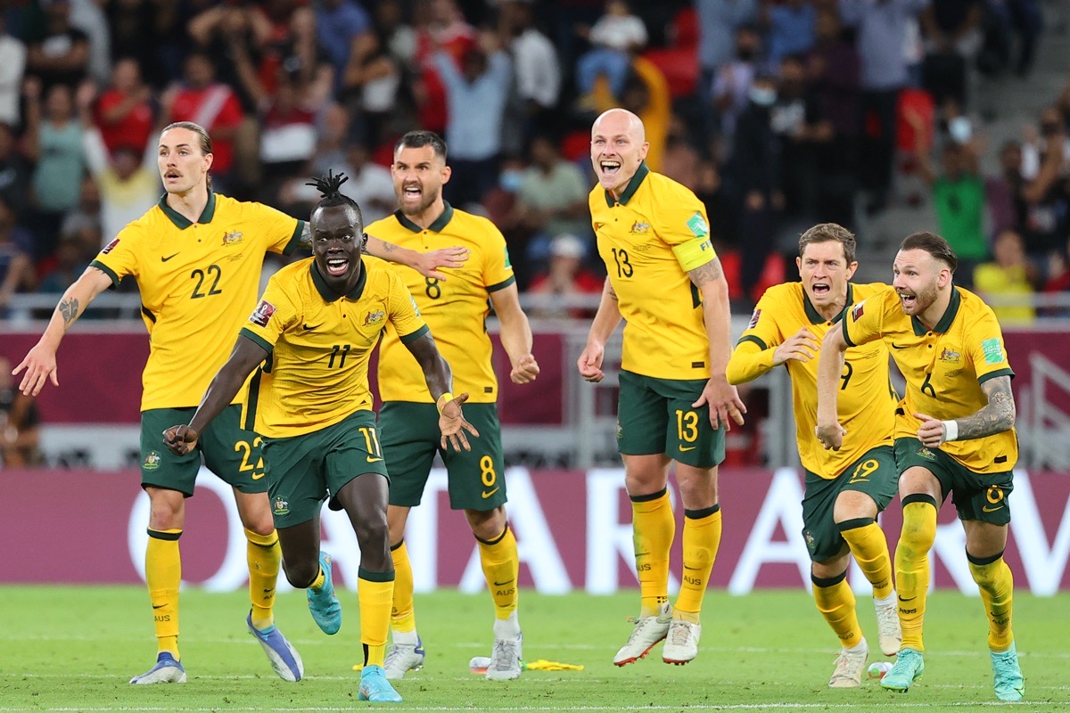 Australische Spieler feiern den Sieg im Playoff-Spiel der FIFA Fussball-Weltmeisterschaft 2022 zwischen Australien und Peru am 13. Juni 2022 im Ahmed bin Ali-Stadion in der katarischen Stadt Ar-Rayyan. - Australien besiegte Peru im Elfmeterschießen und sicherte sich damit den vorletzten freien Platz bei der WM-Endrunde. (Foto von KARIM JAAFAR / AFP)