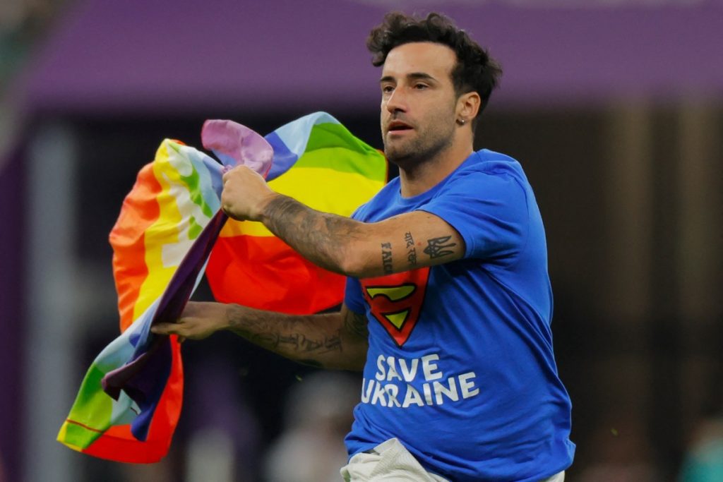 MarionFerri mit T-Shirt "Rettet die Ukraine", läuft während des Fußballspiels der Gruppe H der Fußballweltmeisterschaft Katar 2022 zwischen Portugal und Uruguay im Lusail-Stadion auf das Spielfeld und schwenkt eine LGBT-Regenbogenflagge auf dem Spielfeld. (Foto: Odd ANDERSEN / AFP)