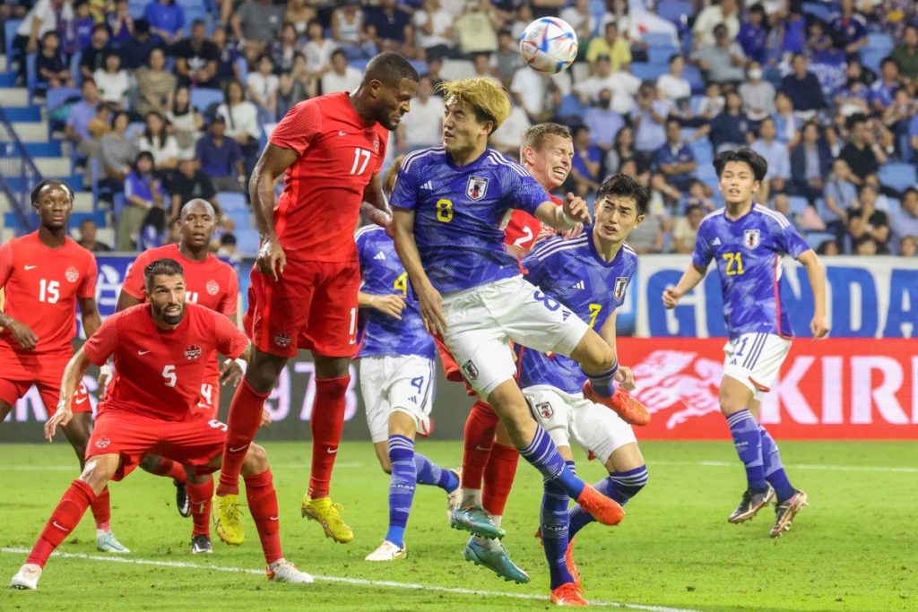 Kanadas Stürmer Cyle Larin und Japans Stürmer Ritsu Doan kämpfen um einen Kopfball während eines Freundschaftsspiels zwischen Kanada und Japan im Al-Maktoum-Stadion in Dubai am 17. November 2022. (Foto: KARIM SAHIB / AFP)