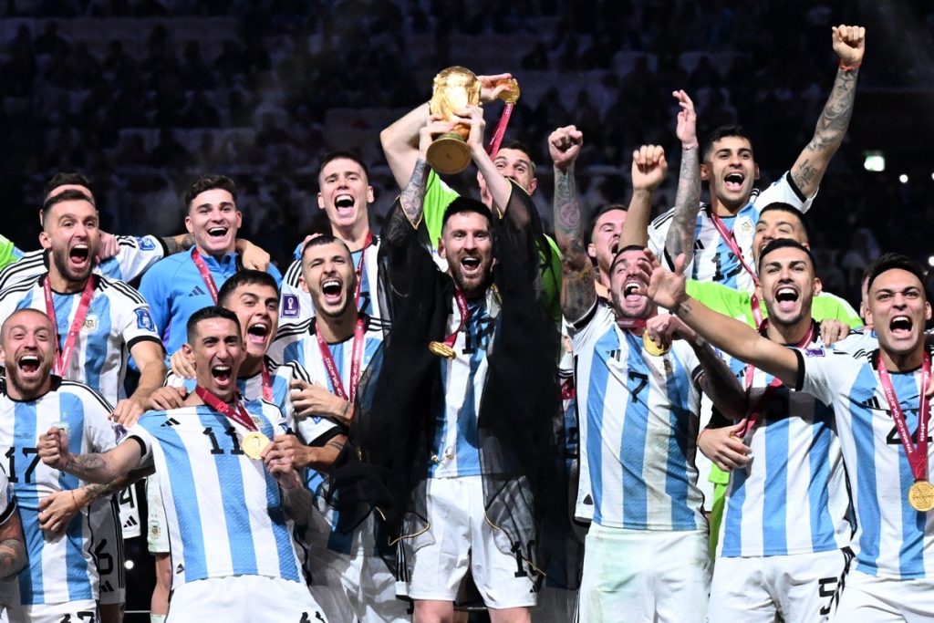 Der argentinische Kapitän und Stürmer Nr. 10 Lionel Messi (C) hebt die FIFA WM-Trophäe in die Höhe, während er mit seinen Mannschaftskameraden den Sieg im Endspiel der Fußball-Weltmeisterschaft Katar 2022 zwischen Argentinien und Frankreich im Lusail-Stadion in Lusail, nördlich von Doha, am 18. Dezember 2022 feiert. (Foto von Kirill KUDRYAVTSEV / AFP)