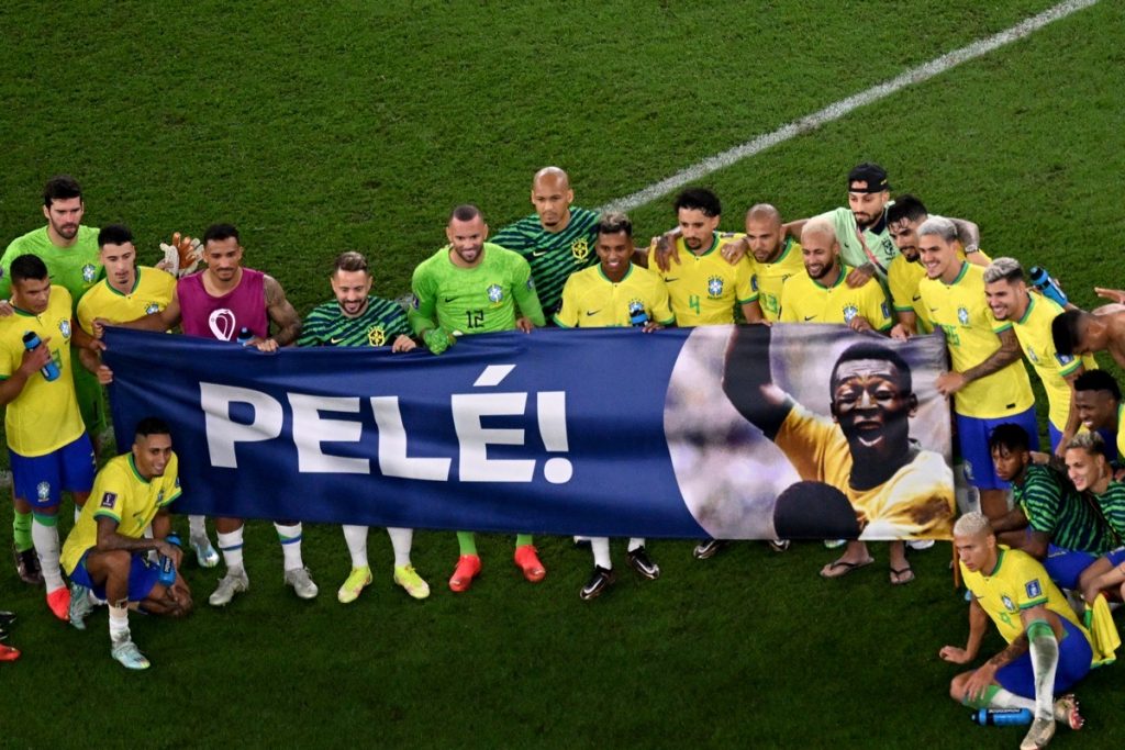 Brasilianische Spieler halten ein Banner, das der brasilianischen Fußballlegende Pelé gewidmet ist, am Ende des Achtelfinalspiels der Fußballweltmeisterschaft Katar 2022 zwischen Brasilien und Südkorea im Stadion 974 in Doha am 5. Dezember 2022. (Foto von Antonin THUILLIER / AFP)